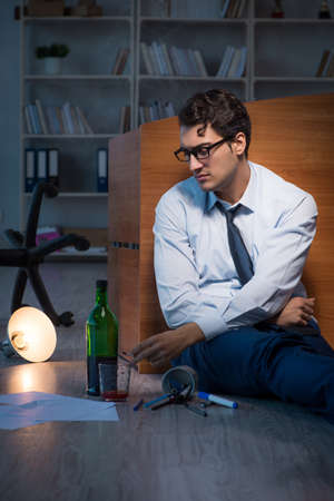 Stressed businessman working overtime in depressionの写真素材