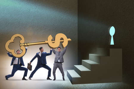 Businessmen with dollar key unlocking doorの写真素材