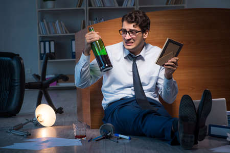 Sad employee in office missing his wife after divorce separationの写真素材