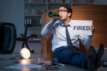 Employee fired during crisis drinking in stress and despairの写真素材
