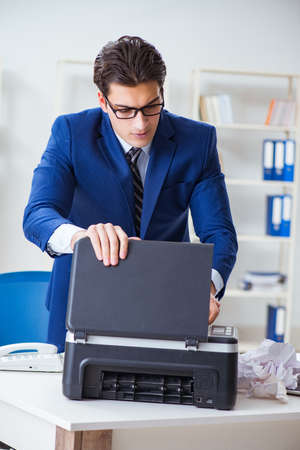 Businessman angry at copying machine jamming papers