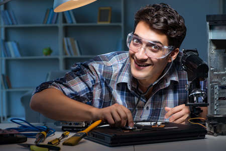 Computer repair concept with man inspecting with stethoscopeの写真素材