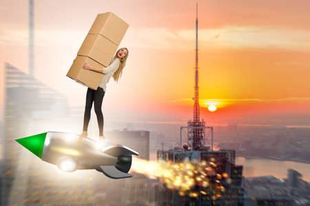 Woman in fast box delivery service on rocketの写真素材