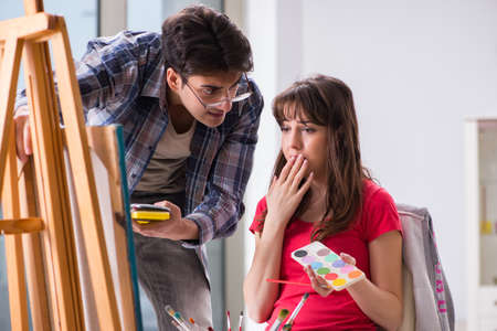 Artist coaching student in painting class in studioの写真素材