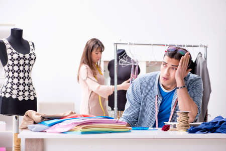 Male tailor with female student in workshopの写真素材