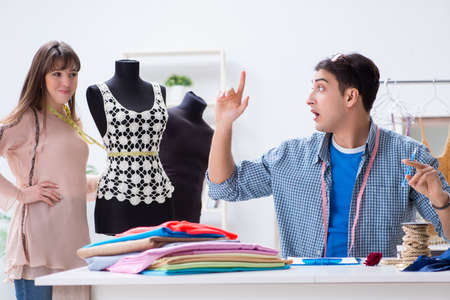 Male tailor with female student in workshopの写真素材
