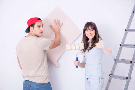Young family doing renovation at home with new wallpaperの写真素材