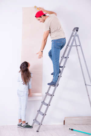 Young family doing renovation at home with new wallpaperの写真素材