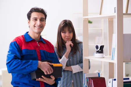 Client getting securty camera installed at home by contractorの写真素材