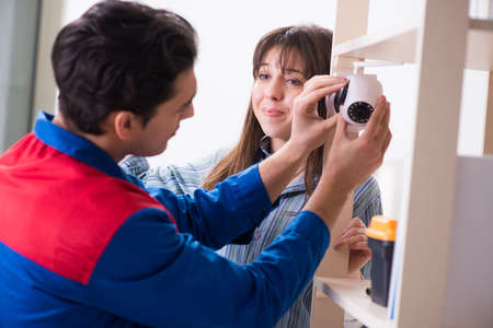 Client getting securty camera installed at home by contractor