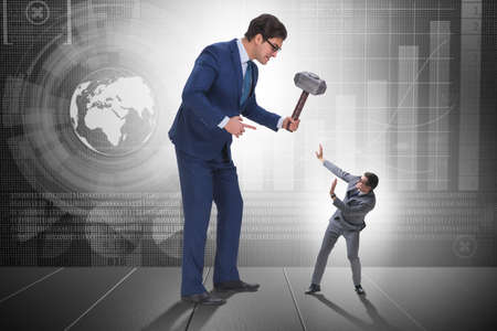 Bad angry boss threatening employee with hammerの写真素材