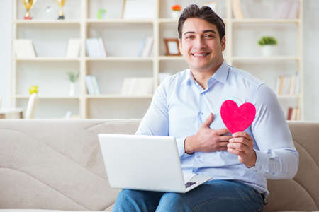 Young man making marriage proposal over internet laptopの写真素材