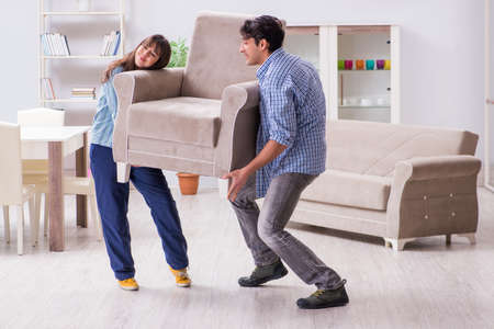 Man moving armchair in the living roomの写真素材
