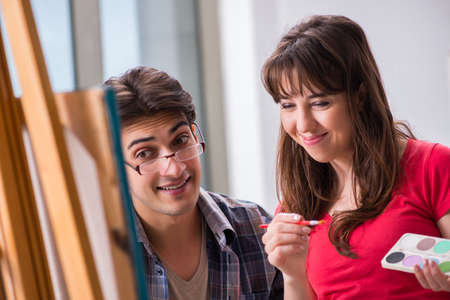 Artist coaching student in painting class in studioの写真素材