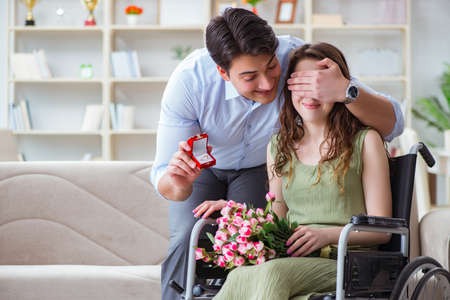 Man making marriage proposal to disabled woman on wheelchairの写真素材