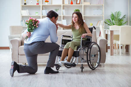 Man making marriage proposal to disabled woman on wheelchairの写真素材