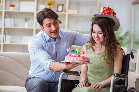 Young family celebrating birthday with disabled personの写真素材