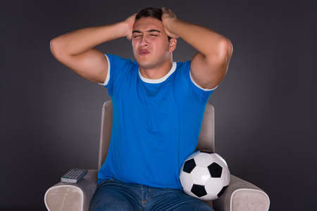 Man watching sports on gray backgroundの写真素材