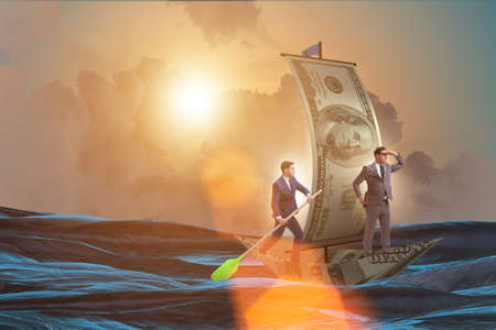Business partnership with businessmen sailing on dollar boatの写真素材