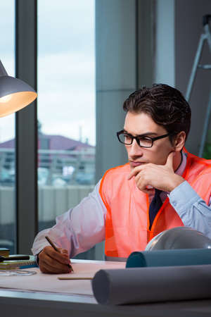 Construction architect working on drawings late at night