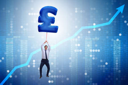 Businessman flying on british pound sign inflatable balloonの写真素材