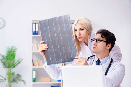 Two doctors examining x-ray images of patient for diagnosis