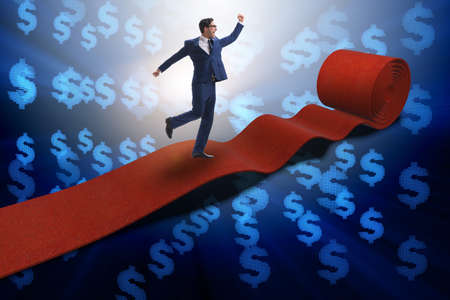 Businessman with dollars on red carpetの写真素材