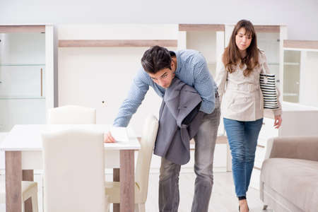 Young couple disappointed with price in furniture storeの写真素材