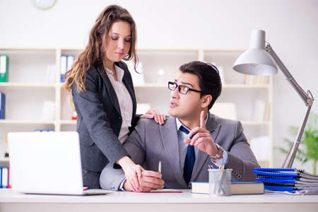 Sexual harassment concept with man and woman in officeの写真素材