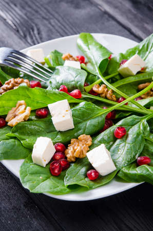 Spinach salad with nuts and apples served on tableの写真素材