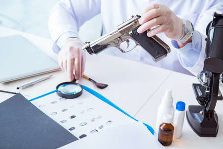 Criminologist police chemist looking at crime evidenceの写真素材