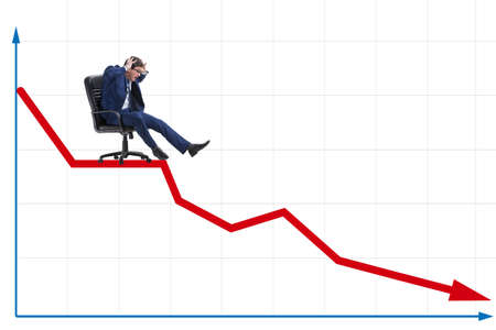 Businessman sliding down on chair in economic crisis conceptの写真素材