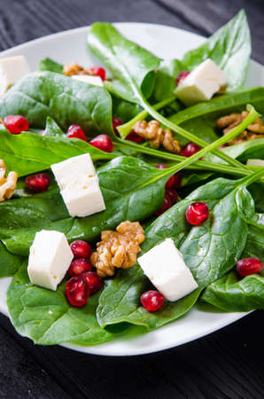Spinach salad with nuts and apples served on tableの写真素材
