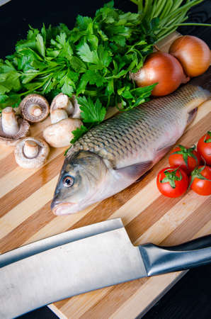 Uncooked fish on cutting board in meal preparation conceptの写真素材