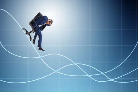 Businessman sliding down on chair in economic crisis conceptの写真素材