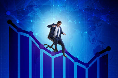 Businessman sliding down on chair in economic crisis conceptの写真素材