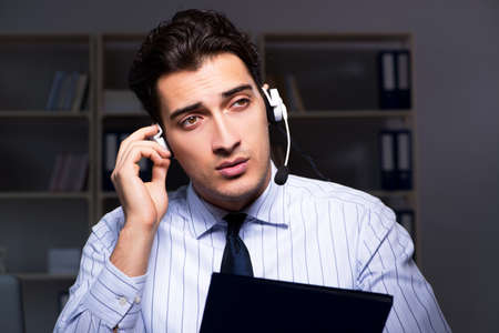 Call center operator talking to customer during night shiftの写真素材