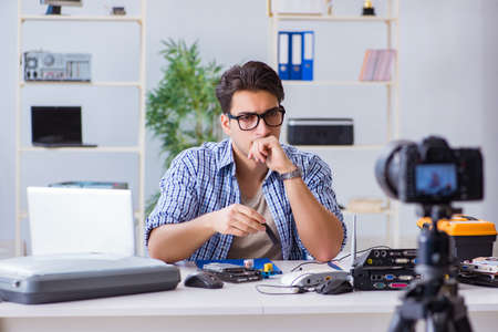 Vlogger recording computer repair on camera for vlog blogの写真素材