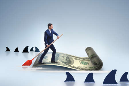 Businessman rowing on dollar boat in business financial conceptの写真素材