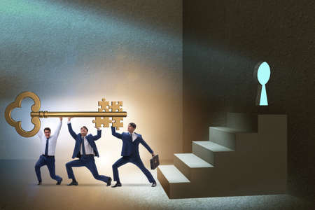 Businessmen with key having jigsaw puzzle elementsの写真素材