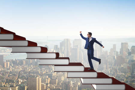 Businessman student climbing the ladder of education booksの写真素材