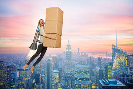 Woman in fast box delivery service on rocketの写真素材