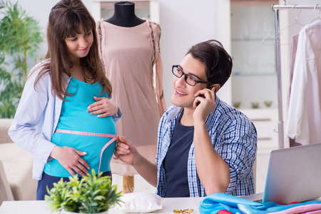 Pregnant woman visiting tailor for new clothingの写真素材