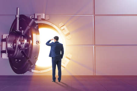 Businessman in front of banking vault doorの写真素材