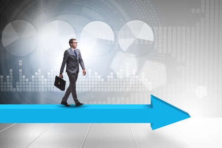 Businessman walking on arrow in business conceptの写真素材