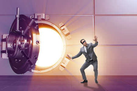 Businessman in front of banking vault doorの写真素材