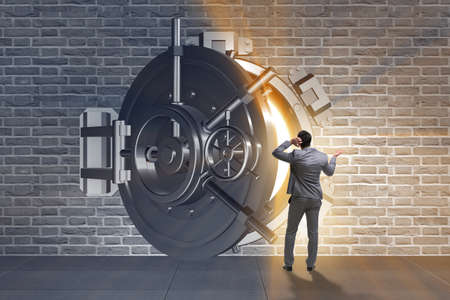 Businessman concerned about theft at banking vault doorの写真素材