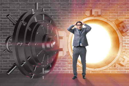 Businessman in front of banking vault doorの写真素材