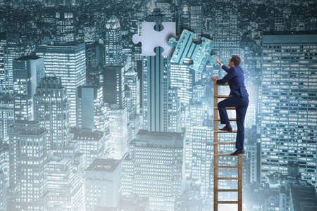 Businessman putting together jigsaw puzzle pieces