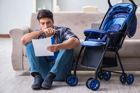 Young father assembling baby pram at homeの写真素材